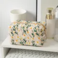 Detaillierte Makroansicht der feinen Gänseblümchen-Stickerei auf einer Kosmetiktasche aus Segeltuch - Quadratische Kosmetiktasche / Beige
