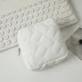 Nahaufnahme einer weißen gesteppten quadratischen Kosmetiktasche mit Reißverschluss auf Tisch - 12.5*12.5*5cm / Weiß