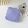 Vista dettagliata di una custodia trapuntata viola con ricamo floreale su fondo bianco. - Viola
