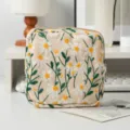 Nahaufnahme der Segeltuch-Kosmetiktasche mit feiner Gänseblümchen-Stickerei-Textur. - Damenbinden-Tasche / Beige