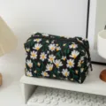 Nahaufnahme einer schwarzen Segeltuch-Kosmetiktasche mit weißen Gänseblümchen - Quadratische Kosmetiktasche / Schwarz