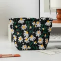 Nahaufnahme der feinen weißen Gänseblümchen-Stickerei auf schwarzer Canvas-Kosmetiktasche - Kleine Clutch / Schwarz