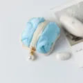Close-up of a blue quilted earphone case with a stylish pearl zipper pull charm - 7*7*4cm / Sky Blue