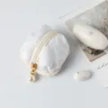 Detailed view of the white quilted cotton earphone case with elegant pearl charm - 7*7*4cm / White