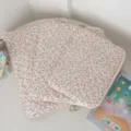 Close-up of three sizes of floral quilted laptop and iPad sleeve bags on a desk - 11" / Pink Floral