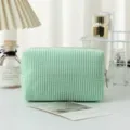 Nahaufnahme grüne Seersucker-Kosmetiktasche mit Streifen und Reißverschluss auf Tisch - 16*9*9cm / Grüne Streifen