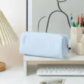 Μπλε και λευκή ριγέ κασετίνα seersucker σε ένα τακτοποιημένο λευκό γραφείο - Γαλάζιες Ρίγες
