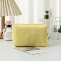 Nahaufnahme der gelb gestreiften Seersucker Kosmetiktasche auf einem weißen Tisch - 16*9*9cm / Gelb Kariert