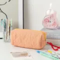 Vue détaillée de la trousse à carreaux orange matelassée avec fermeture éclair jaune. - Carreaux Oranges / Grande Capacité