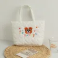Close-up of cute dog embroidery and heart quilting on a white quilted tote bag - Glasses Dog