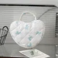 Detailansicht einer weißen gesteppten herzförmigen Kosmetiktasche mit blauen Schleifenmustern - White Background Blue Bow