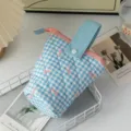 Détail de la trousse matelassée à carreaux bleus avec motif nœud rose et poignée - Carreaux Nœud Bleu