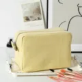 Detail shot of yellow seersucker striped cosmetic bag on a tray with makeup brushes. - 22*9*15cm / Yellow Plaid