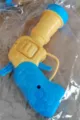 Vista macro di una pistola lanciapalle in plastica blu e gialla per gatti domestici - Singolo / Una pistola giocattolo