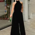 Black halter neck sleeveless jumpsuit detail view, showcasing the stylish print and elegant fit. - S / Solid Black