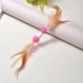 Giocattolo attivo per gatti con bozzolo di seta, pompon rosa e piume divertenti - Lunghezza totale 30 cm / Rosa