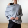 Vue détaillée du élégant pull en tricot gris à épaules dénudées et manches longues. - Taille unique / Gris