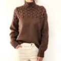 Gros-plan de l'élégant pull à col roulé en maille torsadée marron avec une texture fine. - S / Kaki