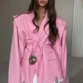 Vue de détail rapprochée d'un élégant blazer rose avec épaulettes et ceinture. - S / Hauts / Rose