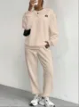 Detailed view of the beige cable-knit sweater and sweatpants lounge set with textured weave. - Apricot with Label