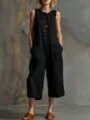 Close-up view of the casual black sleeveless linen jumpsuit with wide legs and button front. - S / Black