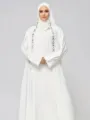 White abaya dress detail featuring elegant black and white geometric embroidery trims. - S / White
