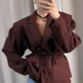 Détail blazer rouge vin pour femme, design élégant avec épaulettes et ceinture à la taille. - Brun Rouge