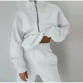 Close-up detail of the casual half-zip fleece sweatshirt and matching sweatpants set. - White