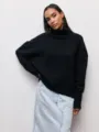 Vue détaillée du pull noir ample à col roulé, élégant vêtement en tricot confortable. - S / Noir