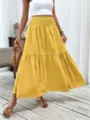 Detailed shot of yellow tiered maxi skirt with high elastic waist, casual resort style look. - Yellow