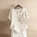 Gedetailleerd overzicht van een dames linnen blouse met korte mouwen en knopen er op. - S / Wit