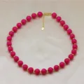 Gros plan detail du collier de perles rondes rose vif avec des perles d'espacement doorees. - Rose Vif (DN260713-A)