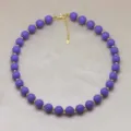 Gros plan de détail sur le collier de perles rondes violettes avec espaceurs dorés et fermoir. - Violet (DN260713-B)