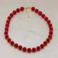 Vue détaillée d'un collier de perles rouges avec des perles d'espacement dorées et une chaînette. - Rouge (DN260713-E)