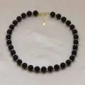 Collier de perles noires avec perles intercalaires dorées gros plan, accessoire bijouterie - Noir (DN260713-H)