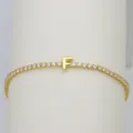 Closeup of gold tennis bracelet with sparkly cubic zirconia stones and cute letter F charm. - Letter F (DB260303-F)