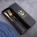 Modern stainless steel cutlery set with black and gold design in a luxury gift box. - Black Gold Cutlery Set in Color Box