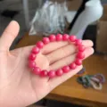 Detailopname van de roze stenen kraalarmband met gladde ronde kralen en fijne textuur. - 8mm / Rozerood