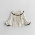 Dettaglio di top in maglia da bambina con grazioso collo a volant e maniche lunghe. - 73cm / Top