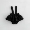 Dettaglio tutina neonata nera con volant, spalline carine e bottoni automatici sicuri. - 73cm / Pantaloni e gonne