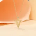 Gold plated letter V pendant necklace detail showcasing the delicate metallic chain and shiny finish. - Letter V