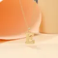 Close-up detail of the gold-plated letter E pendant necklace showcasing its fine texture. - Letter E