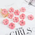 Gros plan de têtes de fleurs artificielles roses avec un centre pailleté pour le bricolage. - Rose rosé