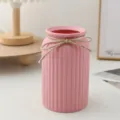 Vase en plastique rose minimaliste avec rayures verticales et nœud en jute pour décoration. - Rose