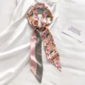 Detail van zijden sjaal met bloemenprint, elegant lang lint voor tas of haar. - Roze Bloemen
