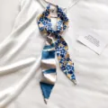 Detail van dunne sjaal, blauw bloemenpatroon en gestreepte achterkant met elegante platte ligging. - Blauw Bloemen