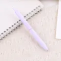 Detailansicht eines eleganten pastelllila Druckkugelschreibers auf karriertem Notizbuch. - Hellviolett