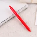 Nahaufnahme roter Gelstift mit weichem Griff Detail auf Notizbuch und Spitzendecke. - Rot