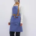 Blue and white striped apron with brown straps and pockets, kitchen cooking baking workwear style. - Blue