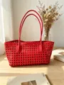 Vista detallada del elegante bolso tote tejido en rojo, destacando su textura y diseño. - Rojo